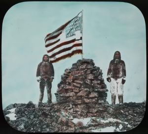 Image: Two Inughuit Men at Cape Columbia Cairn with U.S. Flag